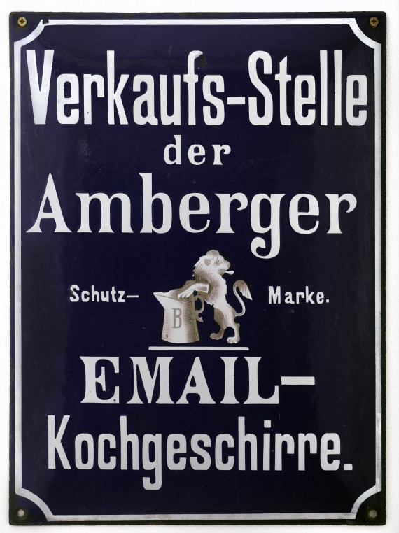 Dunkelblaue Werbetafel aus Email mit Aufschrift: Verkaufs-Stelle der Amberger Email-Kochgeschirre