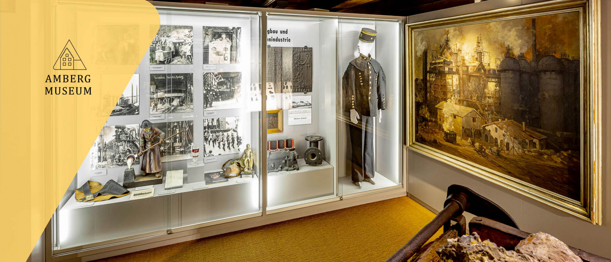 Vitrine mit Objekten und Gemälde zum Thema Erzverarbeitung.